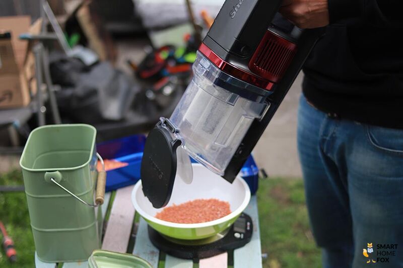 Man sieht, wie der Schmutzbehälter des Shark Anti Hair Wrap Flexology entleert wird.